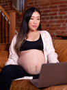 pregnant mom on couch with baby belly supported by beige kinesiology tape. Caption reads "For sensitive skin"