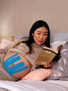 pregnant woman reading with baby belly supported by blue maternity tape. Caption reads "for sensitive skin"